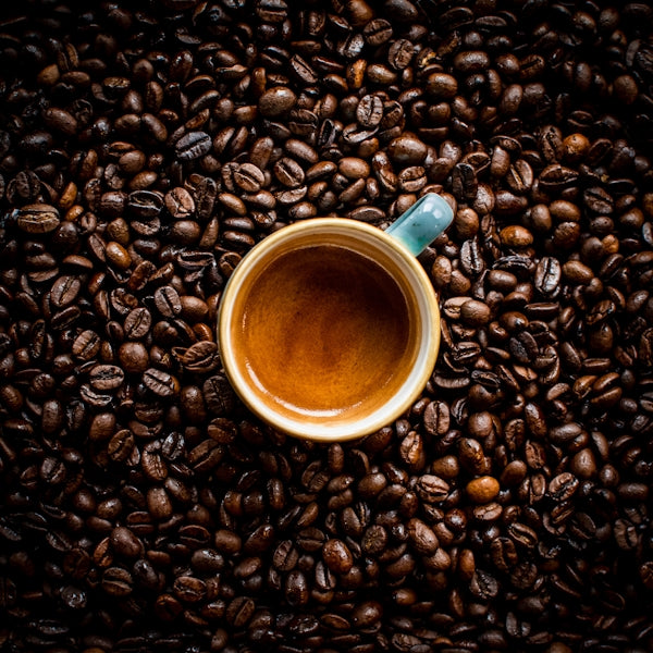 blue ceramic mug on coffee beans