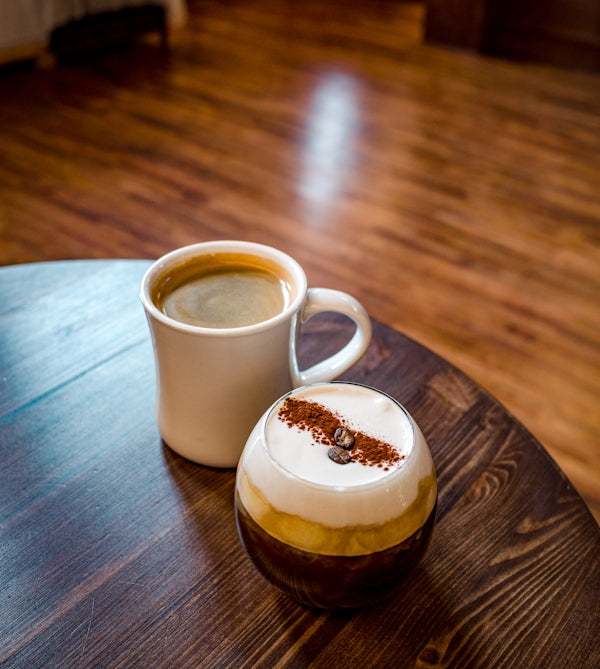 a cup of coffee sitting on top of a wooden table