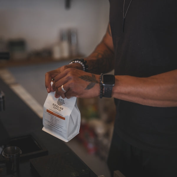 A person opens a bag of coffee.