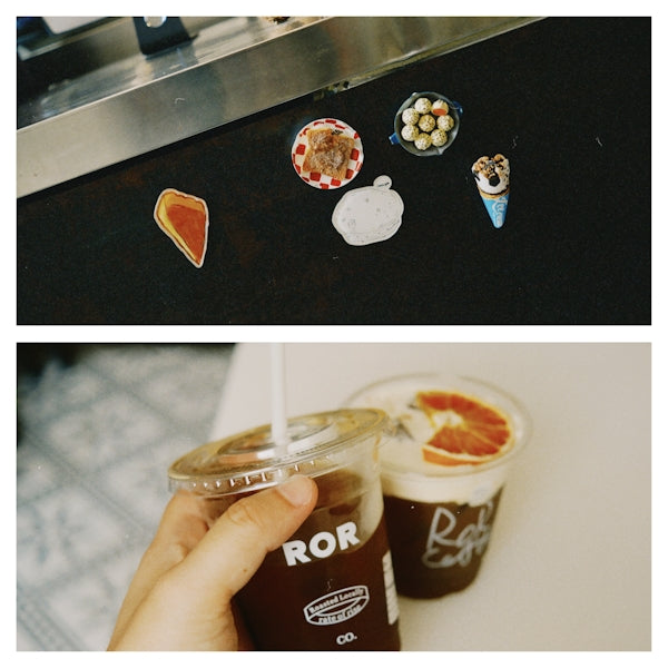 Two iced coffee drinks and various decorative magnets.