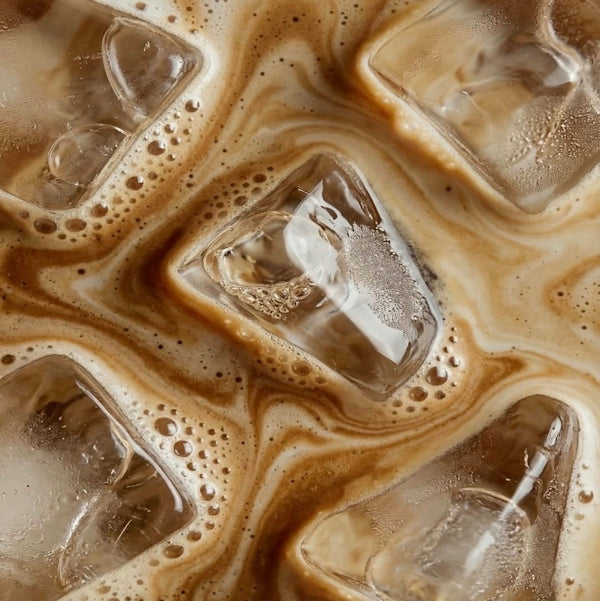 Ice cubes swirling in creamy iced coffee