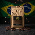 Brown coffee bag with a label on a dark surface with coffee beans, against a Brazilian flag background.