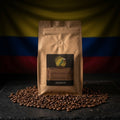 Brown coffee bag with a label on a dark surface in front of a Colombian flag.